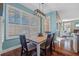 Dining area with a rustic wooden table, modern light fixture and natural light through the shutters at 1881 Riveredge Dr, Tarpon Springs, FL 34689