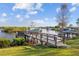 Private boat dock with a boat lift along a tranquil waterfront setting and lush landscaping at 1881 Riveredge Dr, Tarpon Springs, FL 34689
