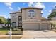 Two-story home featuring neutral stucco, manicured landscaping, and a three-car garage, showcasing curb appeal at 1881 Riveredge Dr, Tarpon Springs, FL 34689