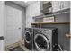 Functional laundry room with modern washer and dryer, ample cabinet space, and organized shelving for convenience at 1881 Riveredge Dr, Tarpon Springs, FL 34689