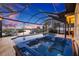 Screened-in pool with a hot tub overlooks a serene waterfront view, offering a luxurious outdoor retreat at 1881 Riveredge Dr, Tarpon Springs, FL 34689