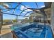 Relaxing backyard with a screened-in pool and hot tub overlooking a scenic waterfront and private dock at 1881 Riveredge Dr, Tarpon Springs, FL 34689