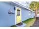 Exterior view of home featuring yellow back door, meter, and landscaping at 245 58Th N St, St Petersburg, FL 33710