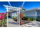 Exterior view of a charming home with an arbor covered in vibrant flowers and blue paint at 245 58Th N St, St Petersburg, FL 33710