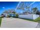 Spacious driveway and fenced yard with a lovely home featuring colorful landscaping at 245 58Th N St, St Petersburg, FL 33710