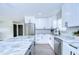Stylish renovated kitchen featuring stainless steel appliances, white cabinetry, herringbone backsplash, and a center island with marble at 245 58Th N St, St Petersburg, FL 33710