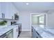 Updated kitchen featuring stainless steel appliances, white cabinetry, herringbone backsplash, and a gray center island with marble at 245 58Th N St, St Petersburg, FL 33710