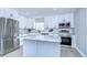 Bright kitchen features white cabinets, stainless steel appliances, herringbone backsplash, and a center island with marble countertop at 245 58Th N St, St Petersburg, FL 33710
