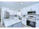 Renovated kitchen with white cabinets, stainless appliances, gray center island, and stylish herringbone backsplash for modern appeal at 245 58Th N St, St Petersburg, FL 33710