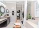 Bathroom features dual sinks, a separate bathtub, a glass shower, and natural light at 27045 Firebush Dr, Wesley Chapel, FL 33544