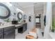 A stylish bathroom offers dual sinks, wallpaper accent, and a relaxing bench seat at 27045 Firebush Dr, Wesley Chapel, FL 33544