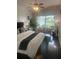 A stylish bedroom featuring pool views, hardwood floors, and a comfortable seating area at 27045 Firebush Dr, Wesley Chapel, FL 33544