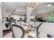 Dining room features a glass table, upholstered chairs and views of the kitchen at 27045 Firebush Dr, Wesley Chapel, FL 33544