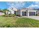 Attractive home exterior with a well-manicured lawn, a three-car garage, and lovely landscaping at 27045 Firebush Dr, Wesley Chapel, FL 33544