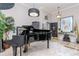 Elegant foyer features a grand piano, chandelier, and marble tile flooring, showcasing sophisticated design at 27045 Firebush Dr, Wesley Chapel, FL 33544