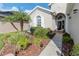 Landscaped front yard with decorative plants and a walkway to the front door at 27045 Firebush Dr, Wesley Chapel, FL 33544
