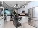Kitchen featuring white cabinetry, stainless steel appliances, granite countertops, and a central island with seating at 27045 Firebush Dr, Wesley Chapel, FL 33544