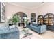 Elegant living room with plush blue sofas, a glass coffee table, and modern decor at 27045 Firebush Dr, Wesley Chapel, FL 33544