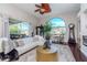 Spacious living room with modern decor, a cozy seating area, a statement window and an outdoor view at 27045 Firebush Dr, Wesley Chapel, FL 33544