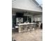 A covered outdoor kitchen featuring a built-in bar, seating, grill, and television, perfect for outdoor entertaining at 27045 Firebush Dr, Wesley Chapel, FL 33544