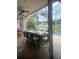 An outdoor kitchen with a large counter island, grill, and seating, overlooking a pool and scenic view for outdoor enjoyment at 27045 Firebush Dr, Wesley Chapel, FL 33544