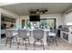 Covered patio with bar-style seating, outdoor kitchen access, and TV at 27045 Firebush Dr, Wesley Chapel, FL 33544