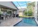 Inviting screened-in pool with a swim-up bar and outdoor kitchen, perfect for entertaining at 27045 Firebush Dr, Wesley Chapel, FL 33544