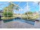 Pool area with a beautiful waterfall feature and scenic backyard pond views at 27045 Firebush Dr, Wesley Chapel, FL 33544