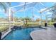 Pool area featuring a scenic pond view under a screened enclosure at 27045 Firebush Dr, Wesley Chapel, FL 33544