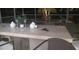 Outdoor wet bar features a stainless grill, a counter with bar stools and decorative accessories at 27045 Firebush Dr, Wesley Chapel, FL 33544