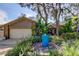 Charming single-story home with mature landscaping, a blue fountain, and a two-car garage at 3089 Enisglen Dr, Palm Harbor, FL 34683