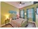 Cozy bedroom featuring colorful bedding, teal curtains, and stylish wall art above a decorative bed at 609 Winterside Dr, Apollo Beach, FL 33572