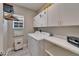 Functional laundry room with washer, dryer, storage cabinets, and shelving at 609 Winterside Dr, Apollo Beach, FL 33572