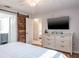 Bedroom with a barn door that provides access to an ensuite bathroom, dresser and wall mounted tv at 7425 118Th Dr, Largo, FL 33773