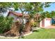 Eye-level view of a single-story home with a lush front yard with mature tree and landscaping at 7425 118Th Dr, Largo, FL 33773