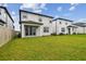 A view of the backyard, featuring a well-maintained lawn, covered patio, and fence for privacy at 7491 Notched Pine Bnd, Wesley Chapel, FL 33545