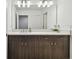 Bathroom vanity with double sinks, modern lighting, and a large mirror at 7491 Notched Pine Bnd, Wesley Chapel, FL 33545