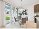 Bright dining area with modern light fixture and sliding glass doors to the backyard at 7491 Notched Pine Bnd, Wesley Chapel, FL 33545