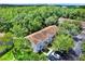 Aerial view of the property nestled within a lush green canopy of trees with ample parking spaces at 8541 Hunters Key Cir, Tampa, FL 33647