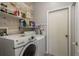 Functional laundry room with washer, dryer, storage shelves, and a door at 9233 Souchak Dr, Trinity, FL 34655