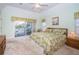 The bright main bedroom features a king bed, ensuite bathroom, and a large window with sliding glass door access at 54 Central Ct, Tarpon Springs, FL 34689