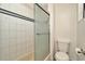 Bathroom featuring white tile in shower with sliding glass doors and toilet at 540 Florida S Cir, Apollo Beach, FL 33572