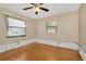 Empty bedroom featuring hardwood flooring, a ceiling fan and two windows at 540 Florida S Cir, Apollo Beach, FL 33572