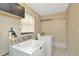 Well-lit laundry room with washer, dryer, overhead cabinets and wire shelving at 540 Florida S Cir, Apollo Beach, FL 33572