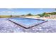 Rectangular community pool surrounded by patterned stone pavers and lounge chairs at 1000 Gulf Blvd # 108, Indian Rocks Beach, FL 33785