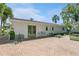 Backyard exterior view with brick patio, white exterior, and lush landscaping at 126 Alora Ne St, St Petersburg, FL 33704