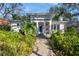 Charming home featuring lush landscaping and a welcoming brick pathway to the front door at 135 Aranda Ne St, St Petersburg, FL 33704