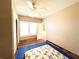 Bedroom with a ceiling fan, natural light, and a glimpse into the hallway at 14124 Plum Ln, Hudson, FL 34667