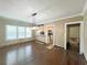 Open dining room with wood floors, modern light fixture, and connecting access to the kitchen at 14124 Plum Ln, Hudson, FL 34667