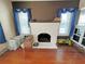 Living room fireplace featuring exposed hardwood floors, white trim, and a brick fireplace at 14124 Plum Ln, Hudson, FL 34667